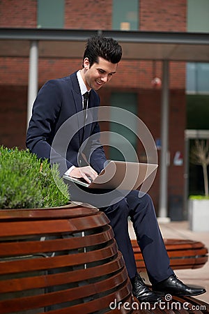 Young businessman working on laptop outside the office Stock Photo