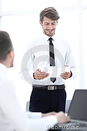 Businessmen communicate in the office. one looks at the tablet Stock Photo