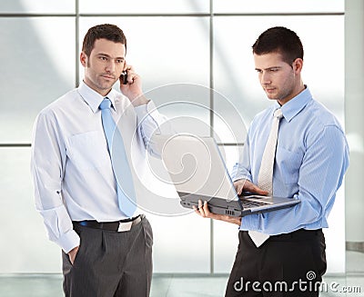 Young businessmen in office lobby Stock Photo