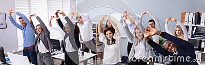 Young Office Workers Doing Stretching Exercise At Workplace Stock Photo