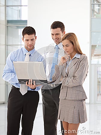 Young businesspeople looking at laptop screen Stock Photo