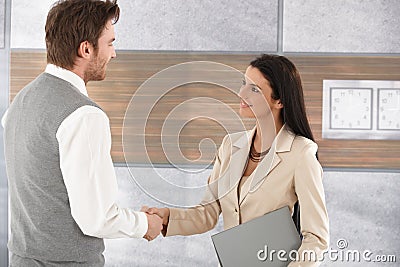 Young businesspeople shaking hands smiling Stock Photo