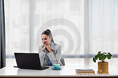 Young businesswoman adjusting to her new workplace after being promoted to a better position in a new office in a global business Stock Photo