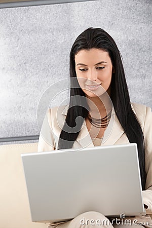 Young businesswoman browsing internet smiling Stock Photo