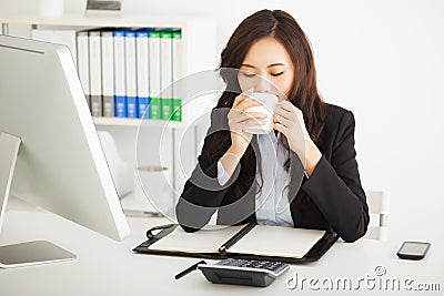 Young businesswoman drinking coffee in office Stock Photo