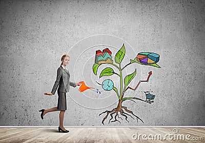 Young businesswoman in empty room watering drawn growth concept with can Stock Photo