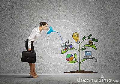 Young businesswoman in empty room watering drawn growth concept with can Stock Photo