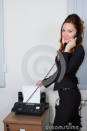 Young businesswoman faxing document Stock Photo
