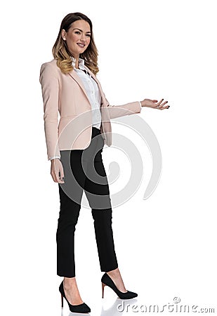 Young businesswoman in high heels presents to side Stock Photo