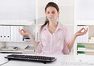 Young businesswoman making a break in the office and meditate. Stock Photo