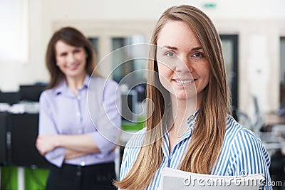 Portrait Of Young Businesswoman With Mentor In Office Stock Photo