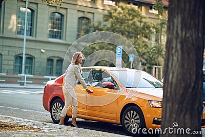 Young businesswoman opening door of a cab, smiling Stock Photo