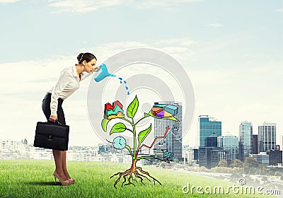 Young businesswoman outdoors watering drawn growth concept with can Stock Photo