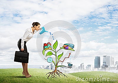 Young businesswoman outdoors watering drawn growth concept with can Stock Photo