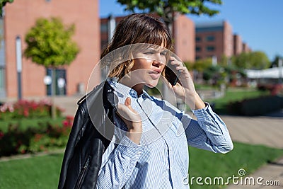 Young businesswoman in park calling by phone Stock Photo