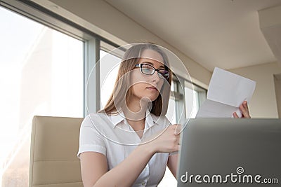 Young businesswoman reading letter at workplace Stock Photo