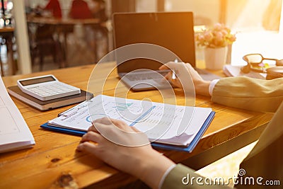 A young businesswoman is reviewing documents and their information to compile statistics and summarize annual results. The concept Stock Photo
