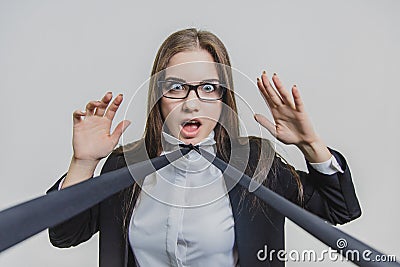 Young businesswoman is shocked and attracted with blue neacktie. She is spreading her hands, trying to run away. Stock Photo