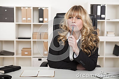 Young businesswoman sitting thinking Stock Photo