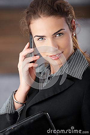 Young businesswoman smiling happily with mobile Stock Photo