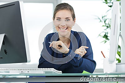 Young businesswoman smiling while working at glass desk Stock Photo