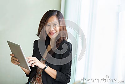 Young businesswoman standing while look at a tablet pc Stock Photo