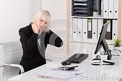 Businesswoman Suffering From Neckache In Office Stock Photo