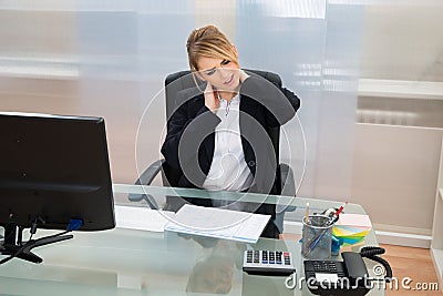 Young businesswoman suffering from neckache Stock Photo