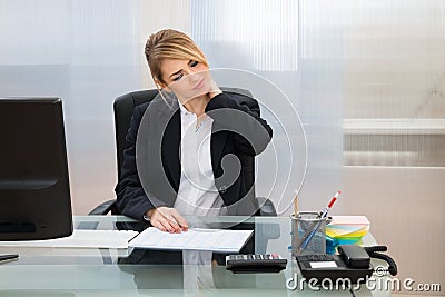 Young businesswoman suffering from neckache Stock Photo