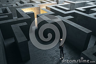 Young businesswoman in suit standing in concerete gray labyrinth Stock Photo