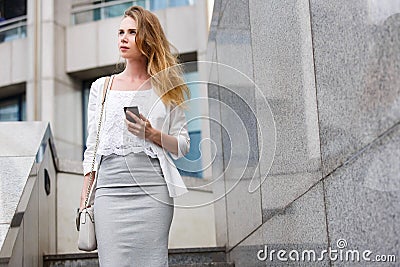 Young businesswoman talking on cellphone while walking outdoor Stock Photo