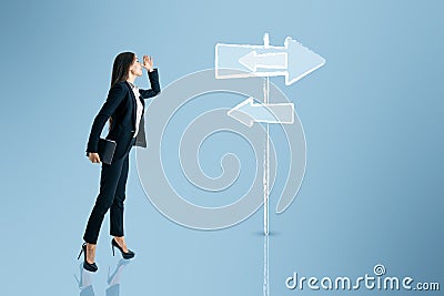 Young businesswoman thinking which path to choose on blue background with sign sketch. Different direction concept Stock Photo