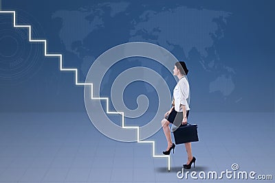 Young businesswoman walking up on stairs Stock Photo