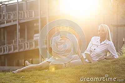 Young businesswomen relaxing on office lawn Stock Photo