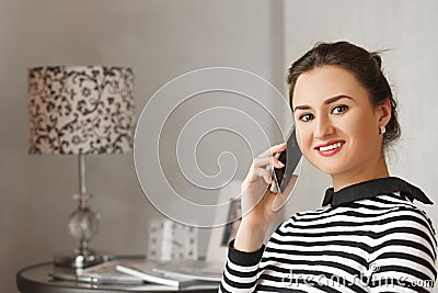 Young bussinesswoman sitting at home and talking with her collegues from work. Stock Photo