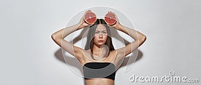 Young busty girl in the studio with grapefruits Stock Photo