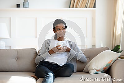 Young calm african american girl sit on sofa Stock Photo