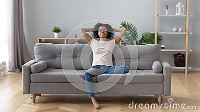 Calm black woman relaxing on comfortable sofa in living room Stock Photo