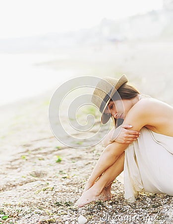 Young calm woman relax sitting on a sand sea beach, romantic foggy morning. Stock Photo