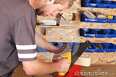 Young carpenter cutting Stock Photo