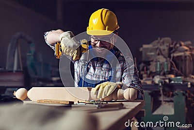 Carpenter drills a hole with an electrical drill Stock Photo