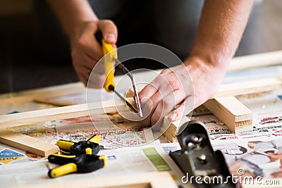 Young carpenter, handyman working with wood, cutting with handsaw Stock Photo