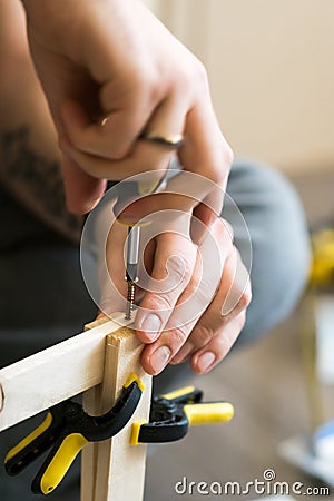 Young carpenter, handyman working with wood, using a screwdriver Stock Photo