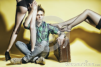 Young casanova man with suitcasen amd female legs Stock Photo