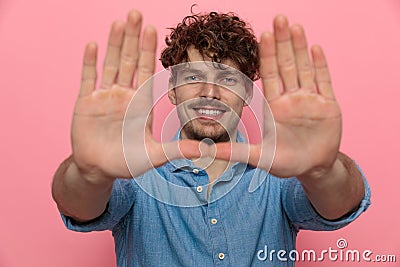 Young casual guy in denim shirt smiling and framing Stock Photo