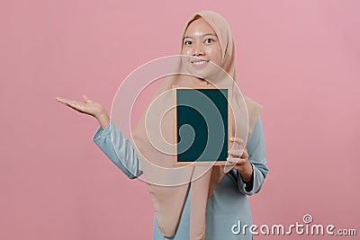 Young casual muslim woman holding green board and showing a copy space Stock Photo