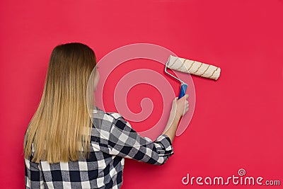 Rear View Of Young Woman Painting Red Wall Stock Photo