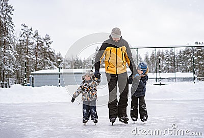 Young caucasian bearded man teach boys how to skate Stock Photo