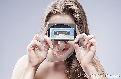 Young Caucasian Blond Woman Holding Audio Cassette In Front Stock Photo