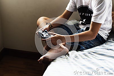 Young caucasian boy holding game control sitting on bed Stock Photo